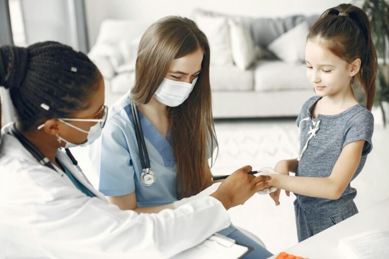 Doctors and a nurse wearing masks attending to a child for a healthcare checkup.